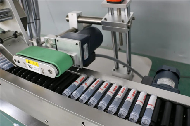 Stroj za etiketiranje lepilnih nalepk z avtomatskim vodoravnim zavijanjem okoli brizge